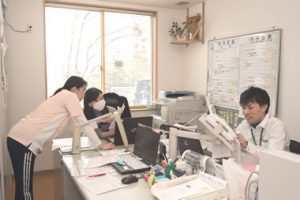 スタッフが複数人で事務作業・書類処理をしている風景