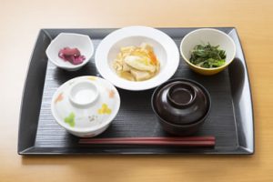 介護施設の食事トレイ。複数の小鉢と主菜が配置された栄養バランスの取れた食事